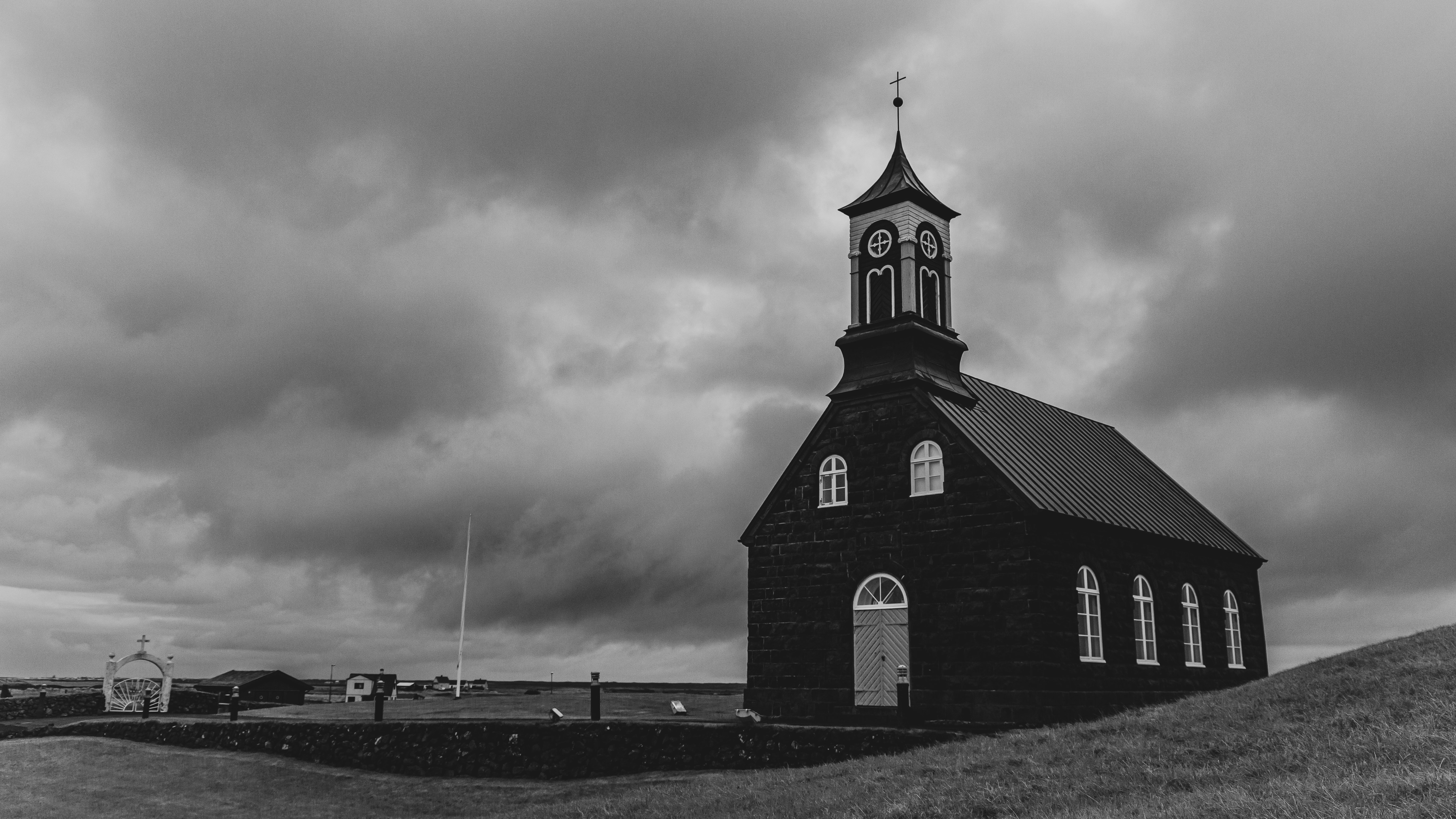 grayscale photo of church under cloudy sky